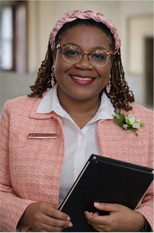 Official portrait of Alderwoman Laura Keys in a pink jacket and white blouse, holding a black folder